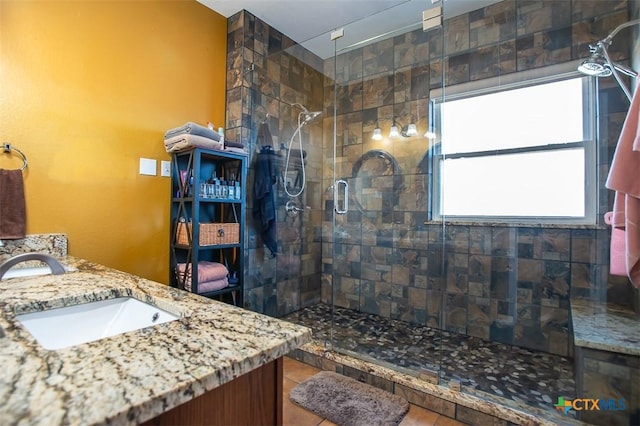 bathroom with tile patterned floors, vanity, and a tile shower