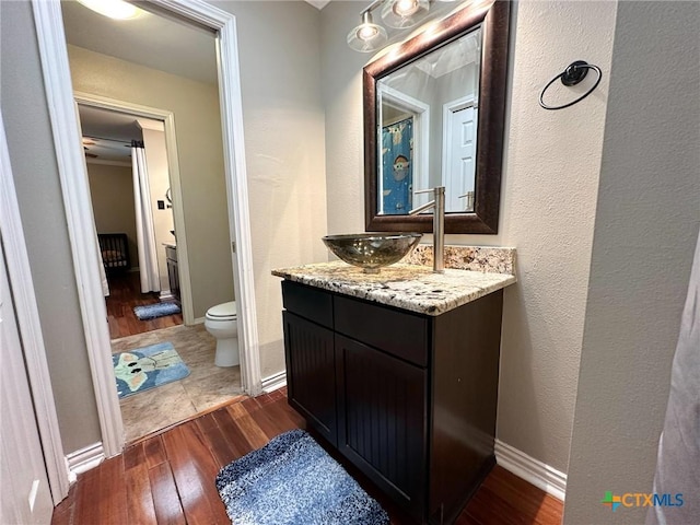 1106 Bowen Ave, Copperas Cove, TX 76522 - bathroom with wood-type flooring, toilet, vanity, and baseboards