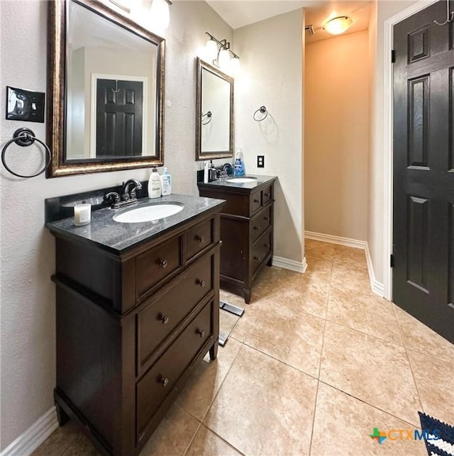 1106 Bowen Ave, Copperas Cove, TX 76522 - bathroom with tile patterned floors, two vanities, and baseboards