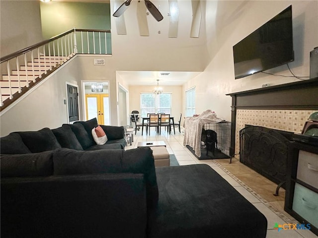 1106 Bowen Ave, Copperas Cove, TX 76522 - tiled living area featuring stairway, a high ceiling, ceiling fan, a tiled fireplace, and a chandelier