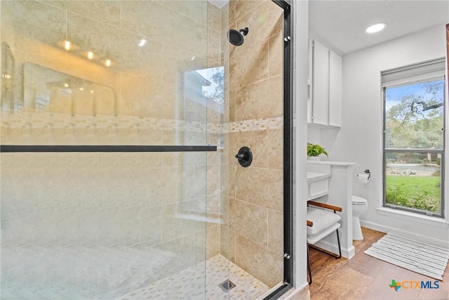 bathroom featuring an enclosed shower, hardwood / wood-style flooring, and toilet