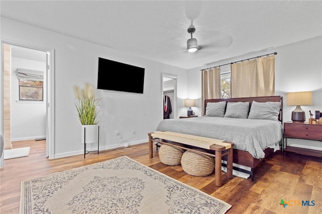 bedroom featuring ceiling fan, wood-type flooring, and a spacious closet