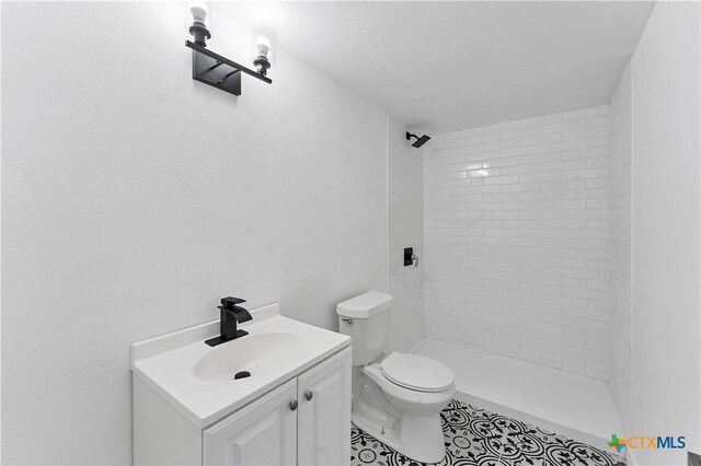 414 Ellis St, Seguin, TX 78155 - bathroom with toilet, tiled shower, and vanity
