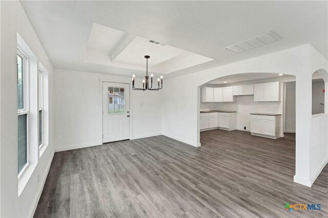 414 Ellis St, Seguin, TX 78155 - unfurnished dining area featuring a raised ceiling, arched walkways, a notable chandelier, and visible vents