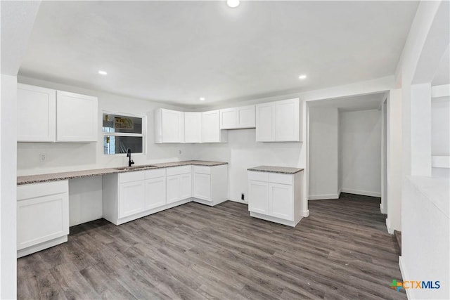414 Ellis St, Seguin, TX 78155 - kitchen with recessed lighting, dark wood-type flooring, a sink, stone counters, and white cabinets