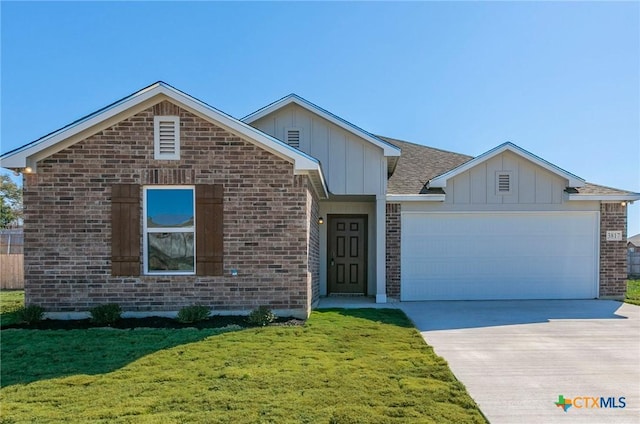 3817 Poteet Ct, Temple, TX 76504 - view of front facade with a front lawn, driveway, board and batten siding, a garage, and brick siding