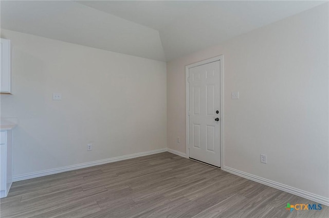3817 Poteet Ct, Temple, TX 76504 - spare room featuring light wood-type flooring, vaulted ceiling, and baseboards