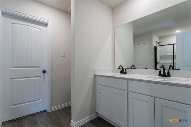 3817 Poteet Ct, Temple, TX 76504 - full bath with baseboards, wood finished floors, a sink, and double vanity