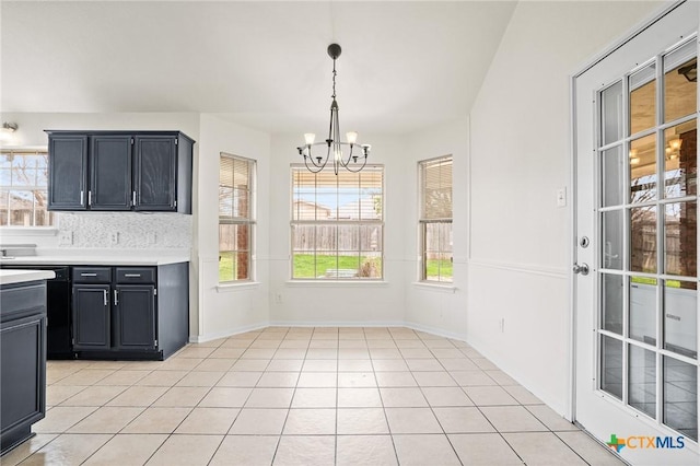 kitchen with dishwasher, light tile patterned floors, tasteful backsplash, a chandelier, and pendant lighting