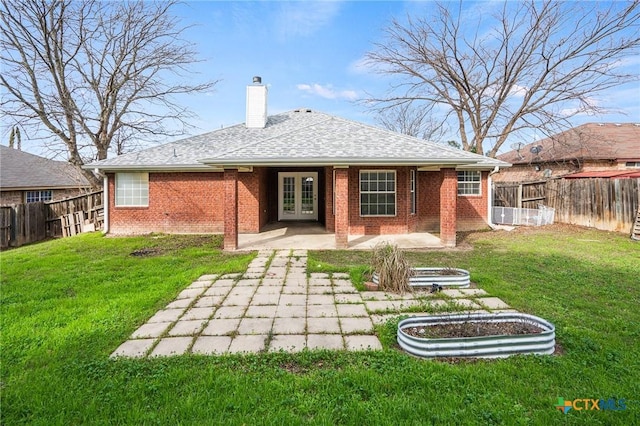 rear view of house with a patio, french doors, and a yard