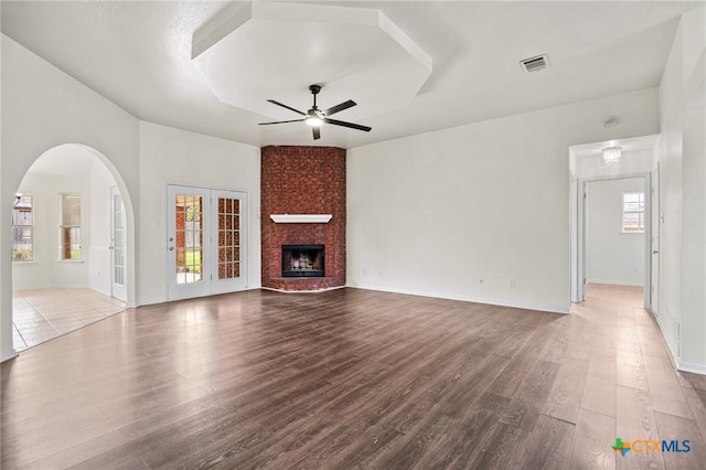 unfurnished living room with ceiling fan, light hardwood / wood-style flooring, and a fireplace