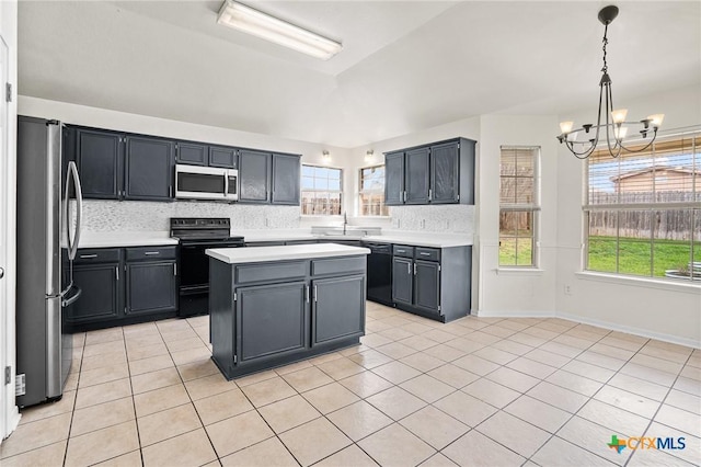 kitchen with a chandelier, hanging light fixtures, a center island, light tile patterned floors, and black appliances