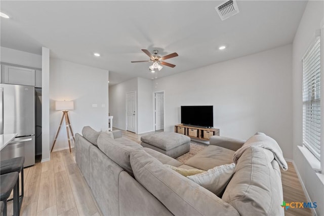 living room with ceiling fan and light wood-type flooring