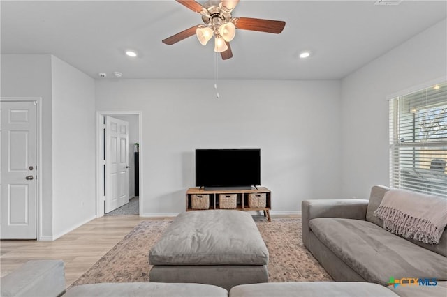 living room featuring ceiling fan and light hardwood / wood-style floors