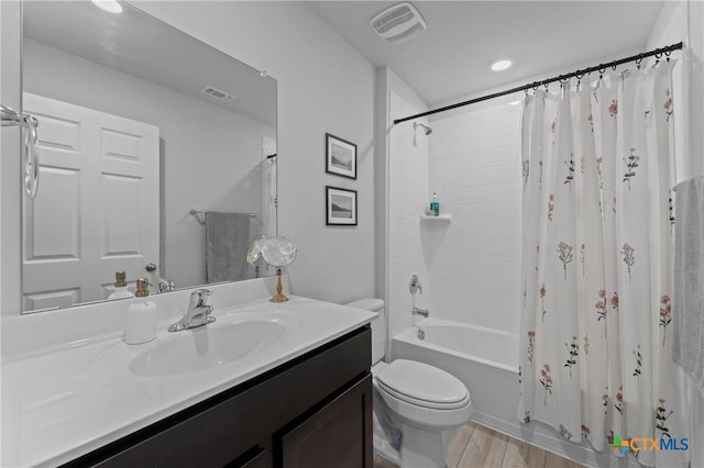 full bathroom with vanity, hardwood / wood-style floors, shower / tub combo, and toilet