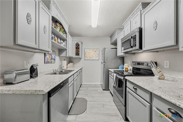 504 Surghnor St, Belton, TX 76513 - kitchen featuring appliances with stainless steel finishes, gray cabinets, light countertops, and a textured ceiling