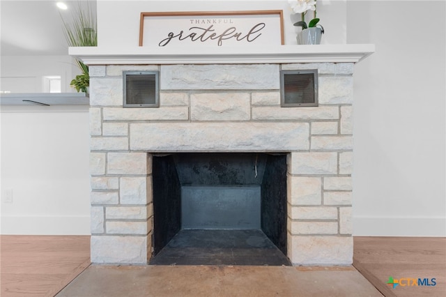 details featuring a stone fireplace and hardwood / wood-style floors