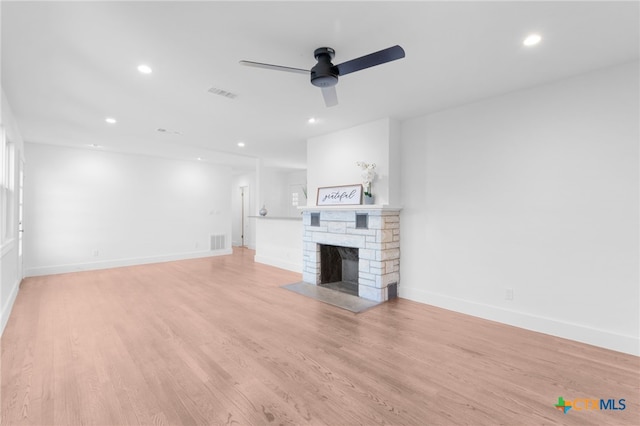 unfurnished living room featuring a fireplace, light wood-type flooring, and ceiling fan