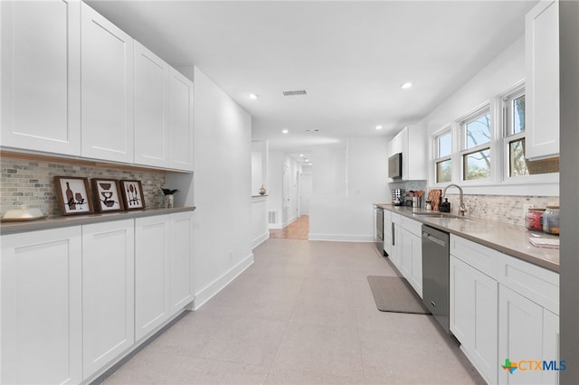 kitchen featuring white cabinetry, stainless steel dishwasher, and sink