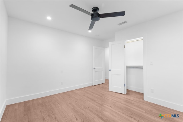 unfurnished bedroom featuring ceiling fan, light wood-type flooring, and a closet