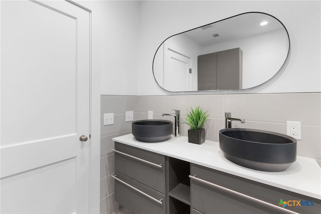 bathroom featuring decorative backsplash, vanity, and tile walls