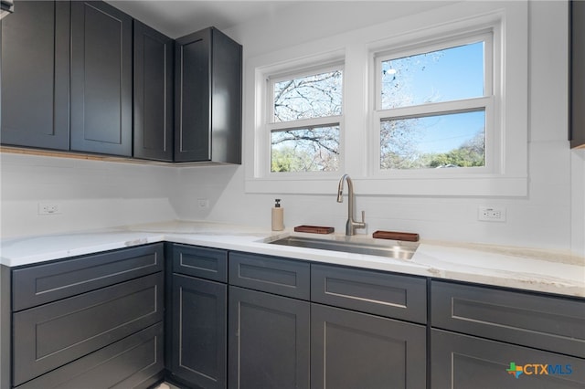 kitchen with light stone countertops and sink