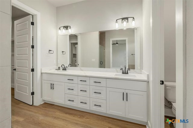 bathroom featuring vanity, hardwood / wood-style flooring, toilet, and ceiling fan