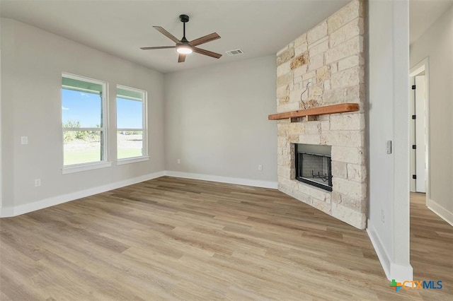 unfurnished living room featuring ceiling fan, a fireplace, and light hardwood / wood-style flooring