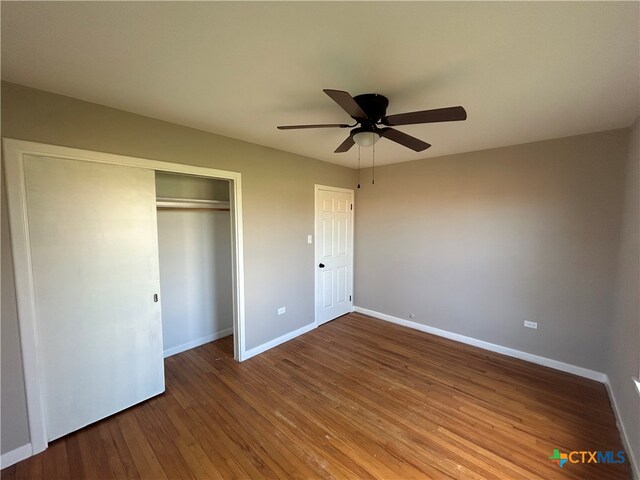 unfurnished bedroom with a closet, ceiling fan, and dark hardwood / wood-style floors