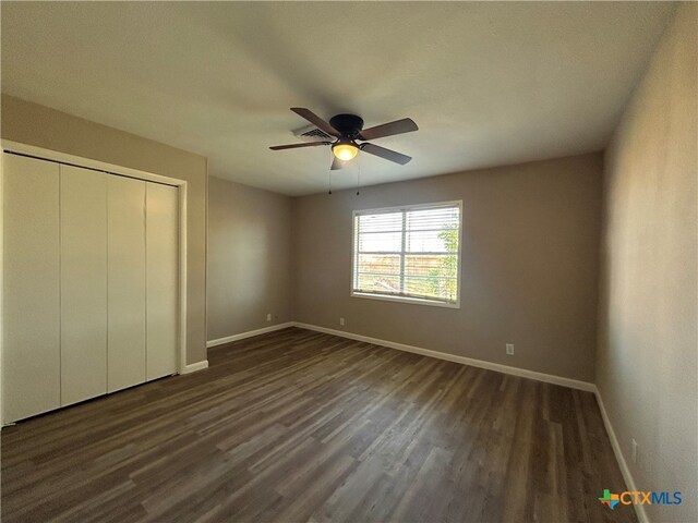 unfurnished bedroom featuring a closet, ceiling fan, and dark hardwood / wood-style floors