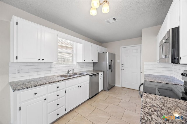 4104 Matt Ct, Killeen, TX 76549 - kitchen featuring a sink, stainless steel appliances, backsplash, stone countertops, and a textured ceiling