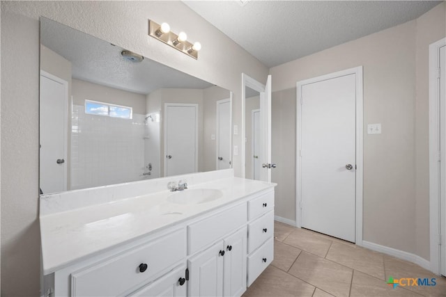 4104 Matt Ct, Killeen, TX 76549 - bathroom featuring vanity, a textured ceiling, a shower, baseboards, and tile patterned flooring