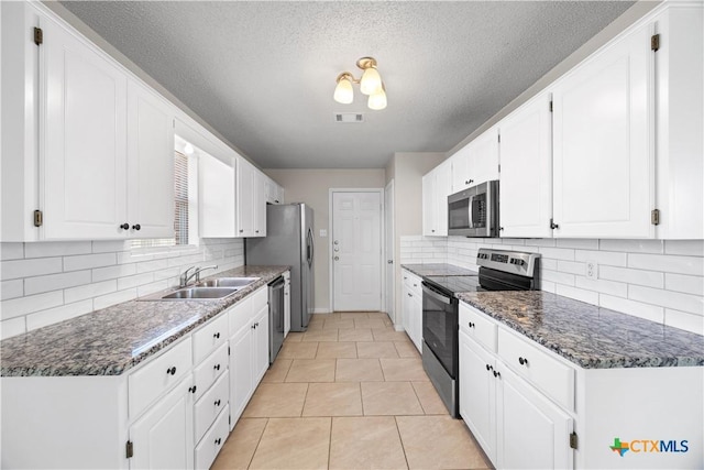 4104 Matt Ct, Killeen, TX 76549 - kitchen featuring stainless steel appliances, a sink, white cabinets, tasteful backsplash, and a textured ceiling