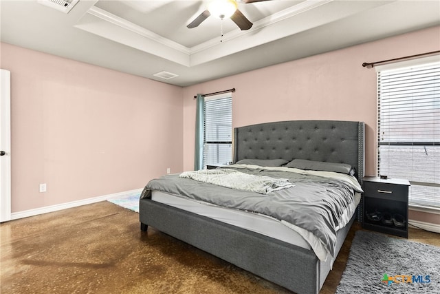 bedroom with multiple windows, a tray ceiling, crown molding, and ceiling fan