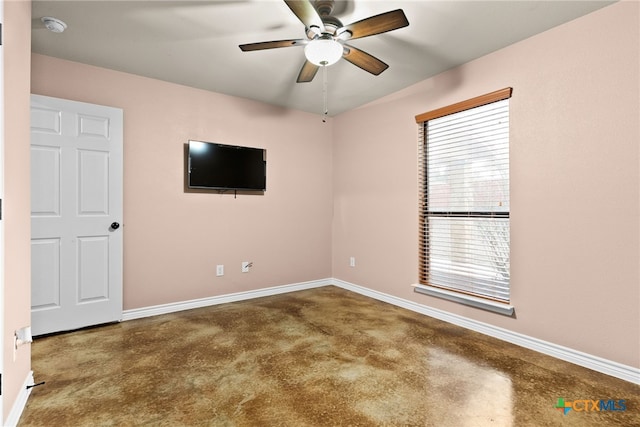 spare room featuring concrete floors and ceiling fan