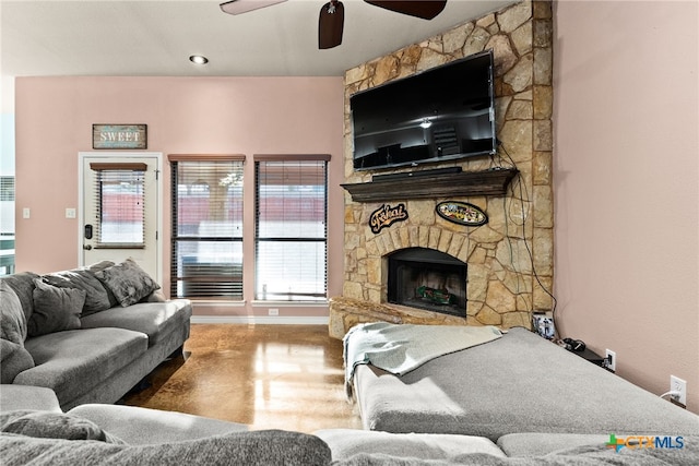 living room with ceiling fan and a fireplace