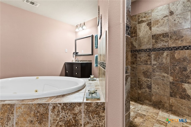 bathroom featuring vanity and independent shower and bath