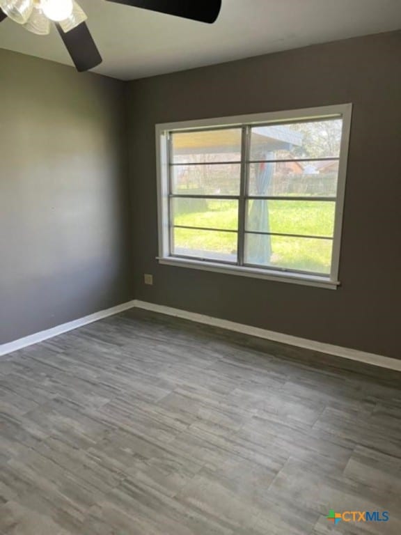 spare room with baseboards and ceiling fan