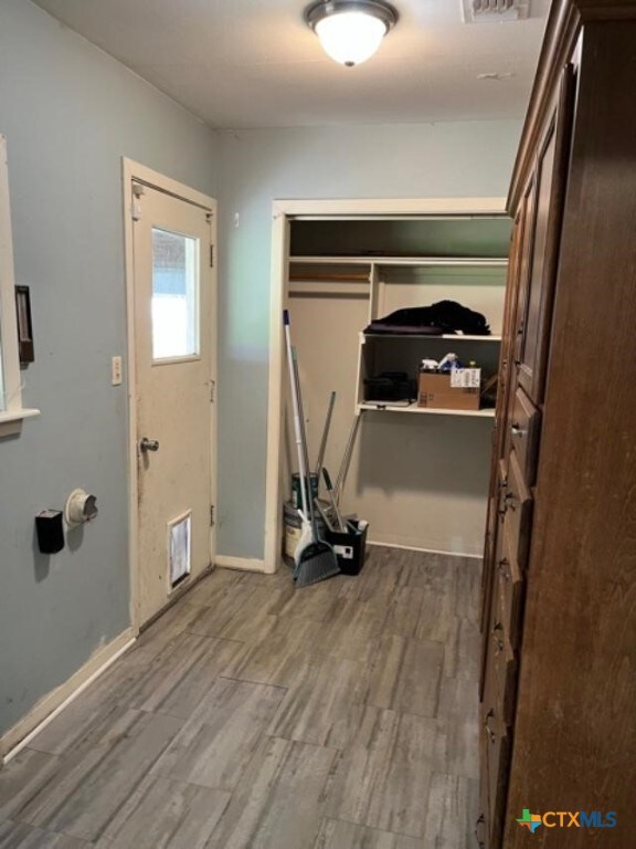 interior space featuring visible vents, baseboards, and dark wood-style flooring