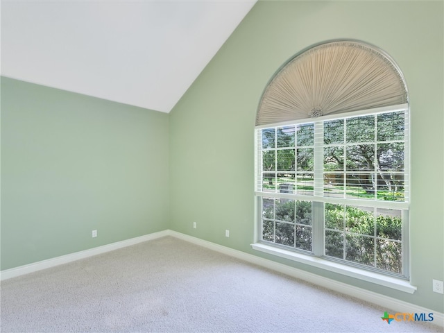 carpeted spare room featuring lofted ceiling