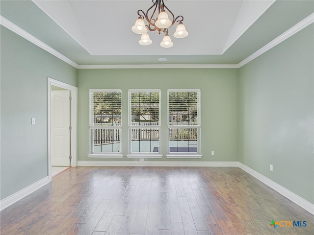 unfurnished room with wood-type flooring, a notable chandelier, and ornamental molding