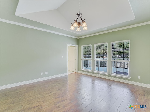 empty room featuring light wood-type flooring, lofted ceiling, an inviting chandelier, and crown molding