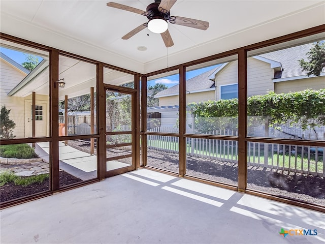 unfurnished sunroom with a wealth of natural light and ceiling fan