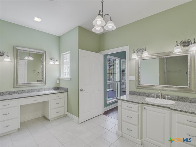 bathroom with tile patterned flooring, vanity, and an inviting chandelier