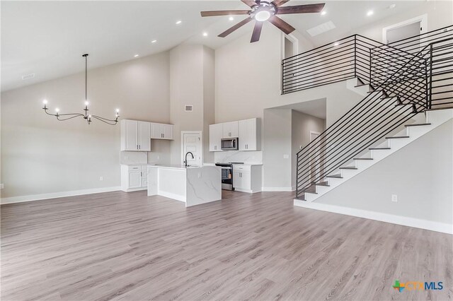 2109 Park View Dr, Marble Falls, TX 78654 - unfurnished living room with high vaulted ceiling, a chandelier, ceiling fan, baseboards, and stairs