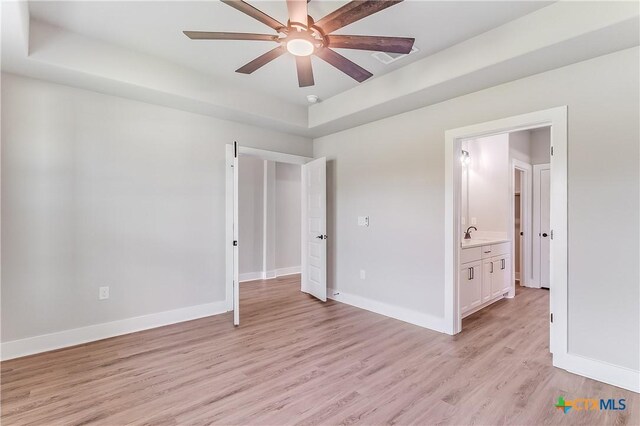 2109 Park View Dr, Marble Falls, TX 78654 - unfurnished bedroom featuring a raised ceiling, light wood-type flooring, baseboards, and a sink