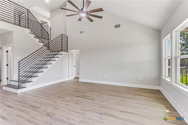 2109 Park View Dr, Marble Falls, TX 78654 - unfurnished living room featuring high vaulted ceiling, ceiling fan, stairway, baseboards, and light wood-style floors