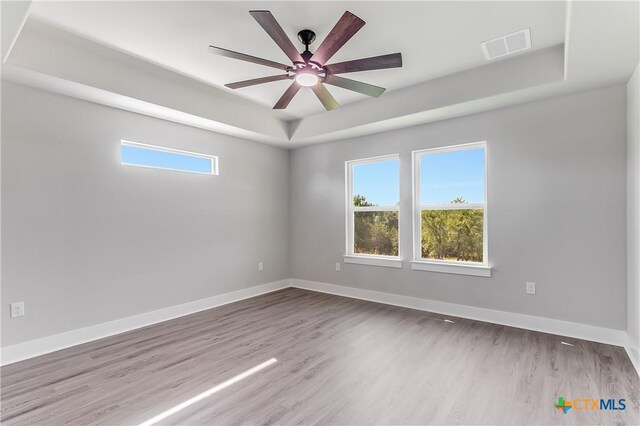 2109 Park View Dr, Marble Falls, TX 78654 - empty room with a raised ceiling, healthy amount of natural light, wood finished floors, and ceiling fan