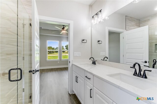 2109 Park View Dr, Marble Falls, TX 78654 - bathroom with ceiling fan, double vanity, a shower stall, wood finished floors, and baseboards