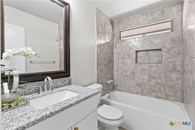 full bathroom with toilet, vanity, and tiled shower / bath